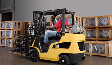 Cat cushion tire class 4 forklift driving in front of boxes